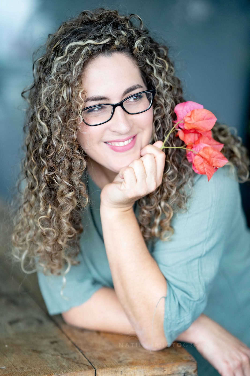 כרמל באומל מחייכת, מחזיקה פרח